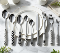 Ensemble de couverts en acier inoxydable à motif blanc et noir, avec poignées en céramique, pour une table de cuisine lumineuse et coordonnée