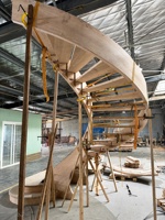 Escalier en colimaçon courbé sur mesure pour villa haut de gamme avec marches en bois massif et rampes en métal