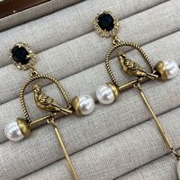 Boucles d'oreilles rétro exagérées en forme de cage à oiseaux dorée avec perles