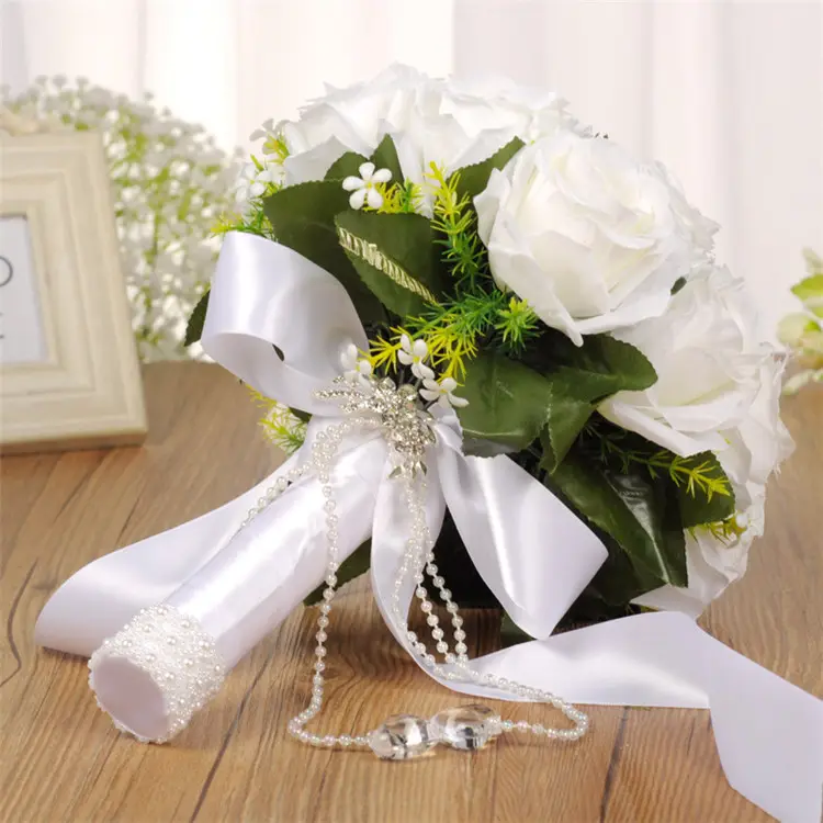 Noiva ocidental criativa do casamento que prende o ramalhete branco das flores artificiais com o ramalhete nupcial do cetim