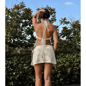 ชุดเซ็ต 2 ชิ้นสำหรับผู้หญิง รุ่นคัสตอม 2026 เสื้อเปิดหลังผ้าลูกไม้และกระโปรงสั้นทรงมินิ ผ้าโพลีเอสเตอร์ผสมเรยอนยืดหยุ่น ระบายอากาศได้ดี เหมาะสำหรับใส่ไปชายหาด - Product Image 2