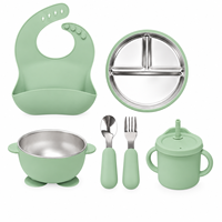 Ensemble de vaisselle en silicone pour bébé avec assiette compartimentée en acier inoxydable, bol à ventouse, bavoir, cuillère, fourchette et tasse à bec.