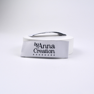Etiqueta blanca ecológica reciclada impresa para el cuidado de la ropa, plegada, con logotipo de silicona en relieve y cinta tejida para prendas. - Product Image 3