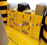 Château gonflable commercial noir et jaune rayé avec double toboggan, idéal pour les entreprises de location