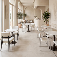 Tables blanches de style minimaliste et chaises rembourrées douces, mobilier commercial pour pâtisserie et café
