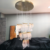 Lustre suspendu décoratif en acrylique courbé avec canopée en laiton brossé couleur champagne et éclairage LED pour projet d'éclairage d'escalier de duplex
