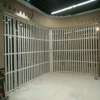 Porte coulissante pliante électrique à enroulement latéral en alliage d'aluminium transparente pour la sécurité des commerces et des centres commerciaux