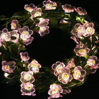 Lampu LED Bertenaga Baterai dengan Desain Bunga Pink, Daun Hijau, dan Ranting Bunga Sakura untuk Dekorasi Natal Dalam Ruangan.