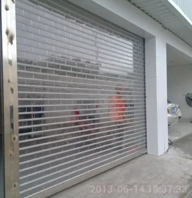 Puerta interior de acordeón de policarbonato con superficie acabada de estilo rodante automática para persianas de seguridad de tiendas y fachadas