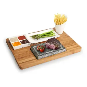 Wooden bamboo serving tray with grill stone and three ceramic side dishes