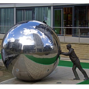 Grande Scultura da Esterno in Bronzo di Uomo che Spinge una Sfera Cava in Acciaio Inossidabile - Product Image 1