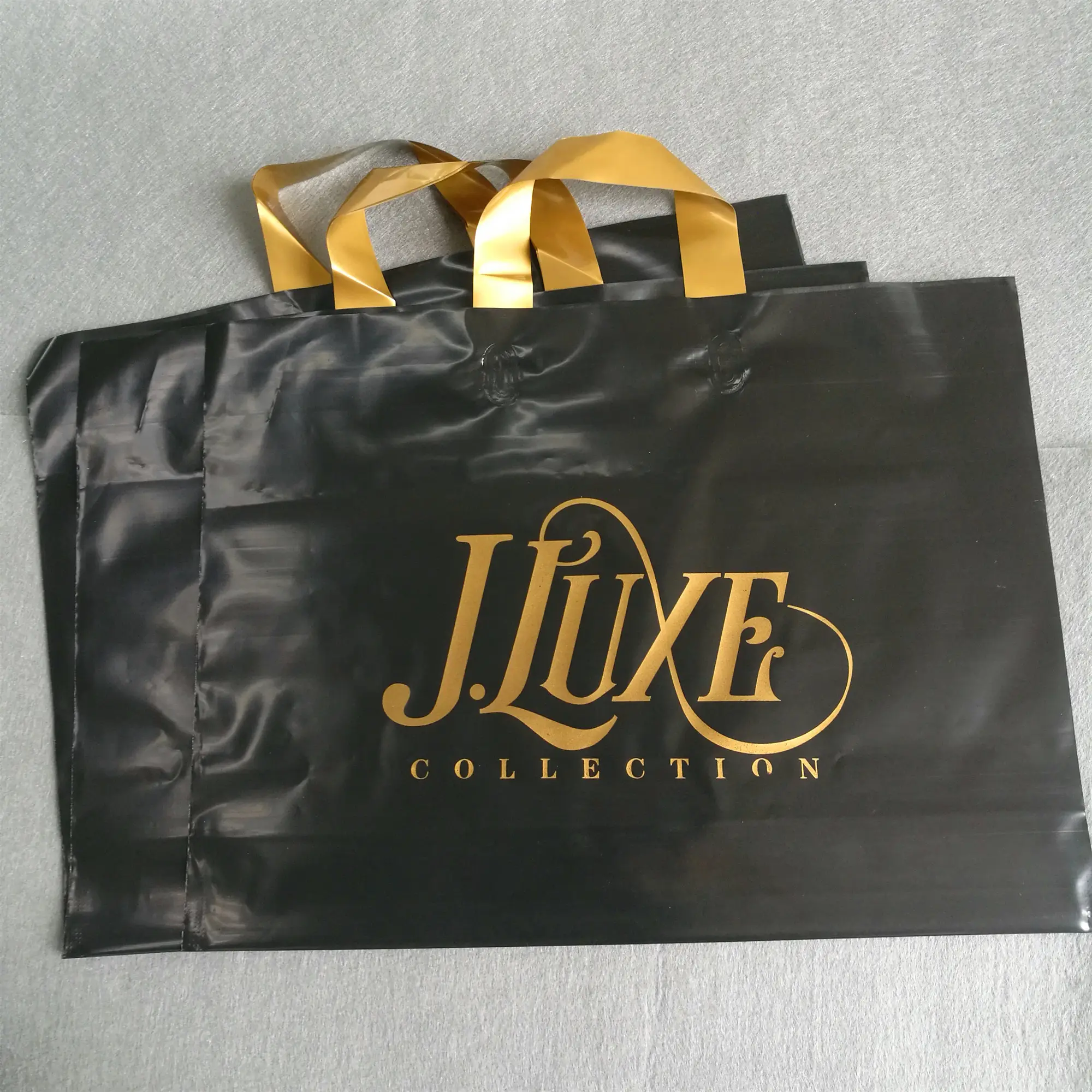 Diseño personalizado de gran tamaño Bolso Negro con oro logotipo impreso LDPE/HDPE suave asa de lazo bolsa para la ropa