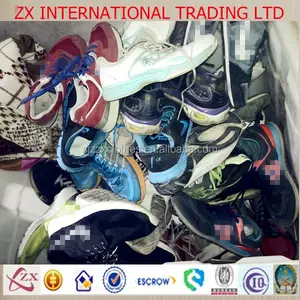 Bulk stock of raw material second hand shoes in the warehouse and sorting into different shoes used shoes in london