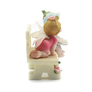 Una bella statua di un angelo bambino su una sedia - Product Image 1