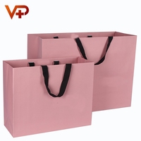 Sac en papier rose poudré personnalisé avec une poignée en cordon et une bordure en gros-grain pour la vente au détail en boutique