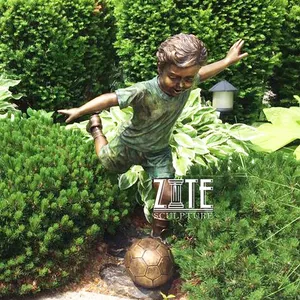 サッカーの子供像を再生する庭の装飾ブロンズサッカーの男の子の彫刻