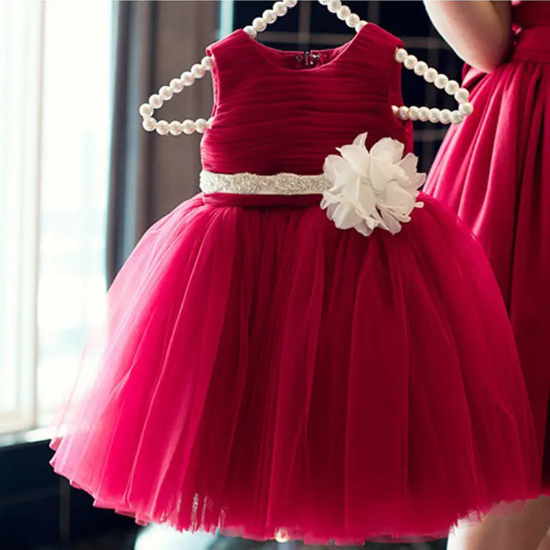 Tangan membuat bayi gadis gaun dalam warna merah dengan busur besar
