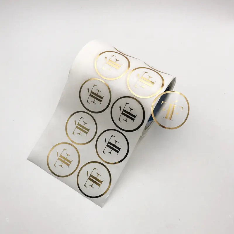 कस्टम मुद्रण चिपकने वाला गर्म मुद्रांकन सोने की पन्नी सील गोल्ड साफ़ पारदर्शी Vinyl उत्पादों स्टीकर लेबल रोल