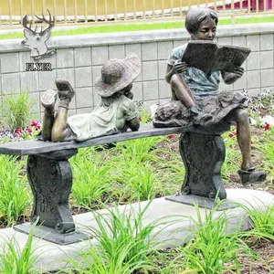 木の丸太の彫刻の本を読んでいる庭の金属工芸品ブロンズ子供像子供たち