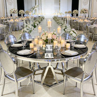 Table de salle à manger ronde de luxe avec plateau en verre noir, base géométrique argentée et structure en acier inoxydable