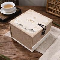 Boîte cadeau rigide en papier pour tasses à thé, avec couvercle articulé et revêtement en lin, personnalisable avec logo et motif, pour l'emballage d'articles de thé.