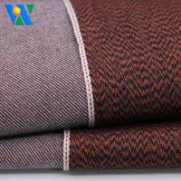 Tela vaquera selvedge de 10.6oz, ligera, con textura especial de espiga ondulada, color naranja gris, tejido de sarga teñido con hilo para jeans.
