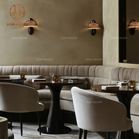 Ensemble de mobilier de café-restaurant : canapé banquette incurvé en velours beige, tables rondes en bois et chaises à assise en tissu pour café