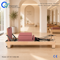 Reformer de Pilates en bois d'érable rose poussiéreux avec rail fixe, barre de repose-pieds intégrée et support à ressorts réglable pour les cours de bien-être