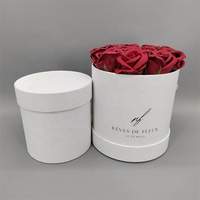 Rose éternelle blanche très vendue pour la Saint-Valentin dans un coffret cadeau rond en carton recyclé avec revêtement UV et logo personnalisé