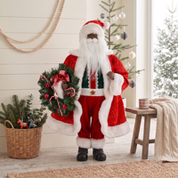 Figurine de Père Noël en noir avec manteau rouge matelassé et couronne de cannes en sucre pour la décoration de Noël à l'entrée de la boutique