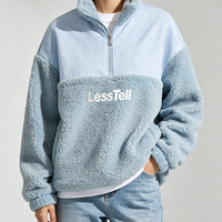 Sweat-shirt à col montant LTD-H1196 en polaire bleue avec empiècements à carreaux, coupe oversize, épaules tombantes, logo sur la poitrine et poches latérales