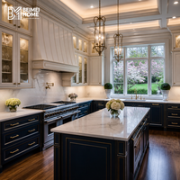 Meubles de cuisine en U de style manoir, bleu marine, avec incrustations en laiton, vitrine supérieure en albâtre, plafond à caissons, menuiserie sur mesure
