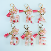 Vente en gros de porte-clés lettre époxy fleur pendentif résine cristal pendentif papillon gland porte-clés pour femmes sac portefeuille sac à main pendentif