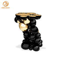Table d'appoint de luxe noire et or avec base sphérique sculpturale et plateau brillant, élégante table de chevet pour hôtel, villa, salon
