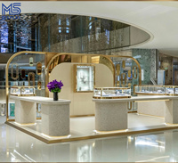 Comptoir de présentation de bijoux de luxe sur mesure avec cadre en arche doré, éclairage LED et base en marbre pour magasin de bijoux et boutique de détail
