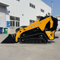 Derette V1000 Mini Skid Steer Loader dengan Berbagai Fungsi Lampiran: Bucket, Grapple, Mulcher, Mesin Diesel Kubota, dan Sistem Crawler.