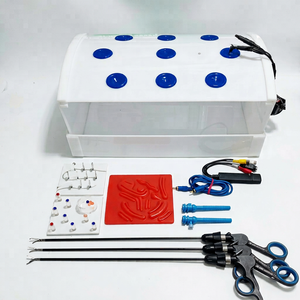 Simulador de entrenamiento laparoscópico rectangular con pinzas, tijeras y accesorios para práctica quirúrgica. - Product Image 1