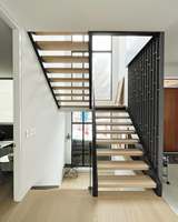 Escalier moderne en bois massif avec poutre monobloc en acier inoxydable et garde-corps en verre, écologique et durable pour villa intérieure