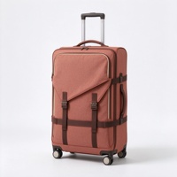 Valise à roulettes souple rouge rouille avec poche avant à rabat à boucle, sangles de compression et poignée télescopique