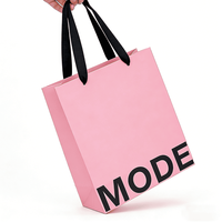 Sac cadeau en papier rose clair avec logo imprimé, poignée en ruban de satin noir, sac fourre-tout minimaliste personnalisé pour l'emballage de vente au détail