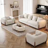 Canapé d'intérieur moderne avec accoudoirs arrondis rembourrés en blanc, pieds décoratifs en bois et coussins décoratifs pour salon