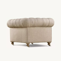 Fauteuil Chesterfield classique capitonné en lin crème, fauteuil club avec accoudoirs roulés et pieds à roulettes, design sud-ouest pour villa
