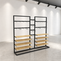 Étagère de présentation de vêtements en métal noir double face à deux niveaux avec étagères en bois et base en U – Vente en gros
