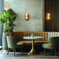 Ensemble de meubles de café moderne, restaurant, table ronde en marbre avec base dorée, fauteuils verts et canapé en cuir brun