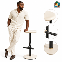 Tabouret de bar minimaliste en fer thermolaqué avec assise ronde mate, pied unique et repose-pieds incurvé, base circulaire plate