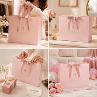 Sac de courses élégant et professionnel en papier blanc avec nœud, imprimé en héliogravure personnalisé pour les marques de vêtements de créateurs et les cadeaux de mariage