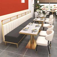 Banquette de restaurant confortable et légère en cuir gris à dossier haut, base de table basse dorée et chaise de restaurant blanche