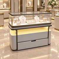 Comptoir de présentation de bijoux commercial, vitrine en verre aux coins arrondis, base de rangement éclairée pour les magasins de vente de bijoux