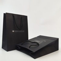 Sacs shopping en papier personnalisés avec logo, sacs cadeaux noirs de luxe avec poignées pour l'emballage de vêtements de boutique