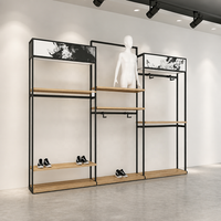 Présentoir mural multi-emplacements en métal noir pour vêtements, avec plateforme pour mannequin et étagère en bois, usage commercial